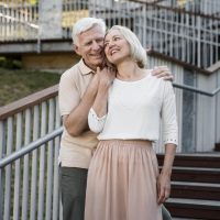 front-view-loving-senior-couple-posing-outdoors